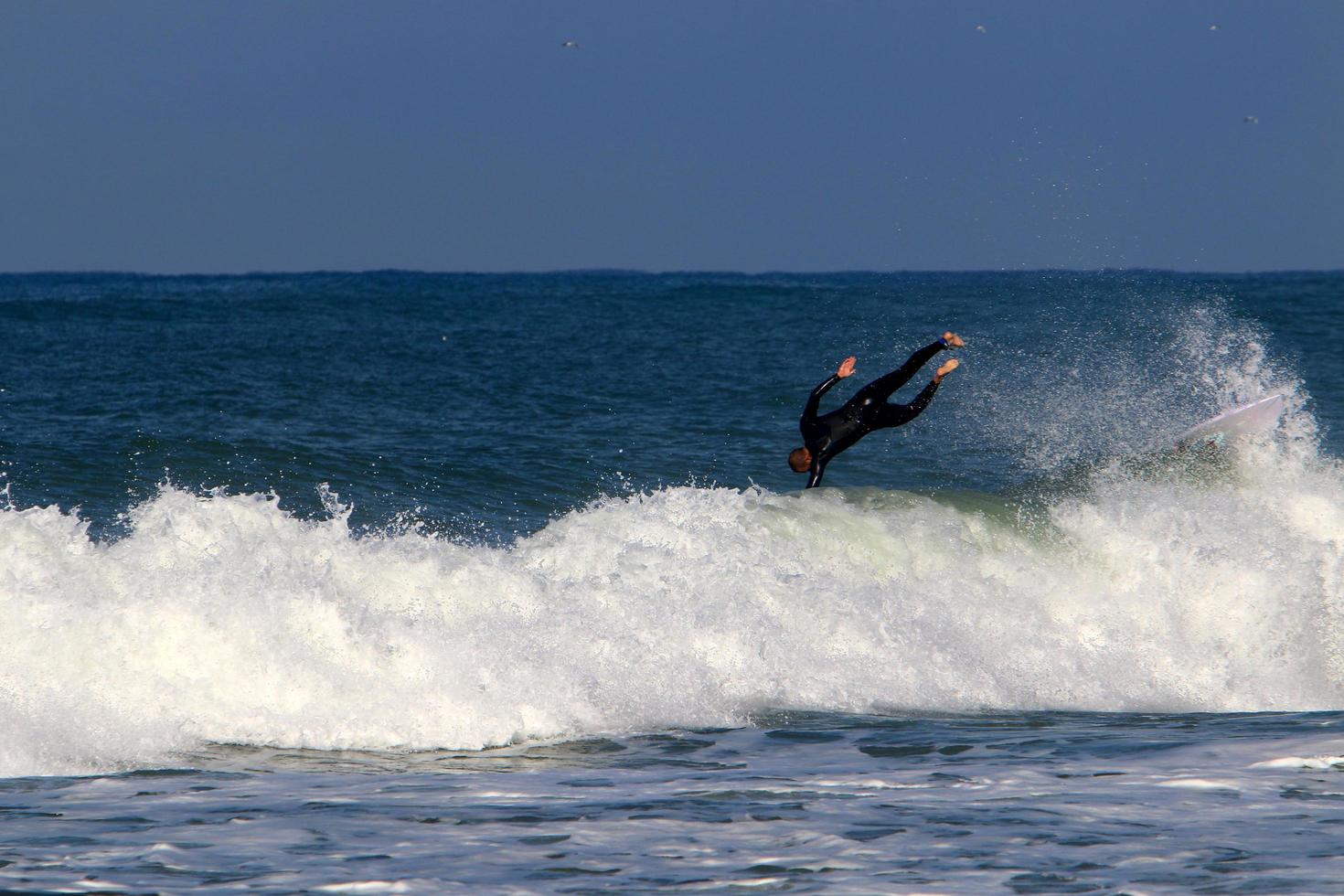 December 21, 2018 Israel. Surfing on high waves in the Mediterranean. photo