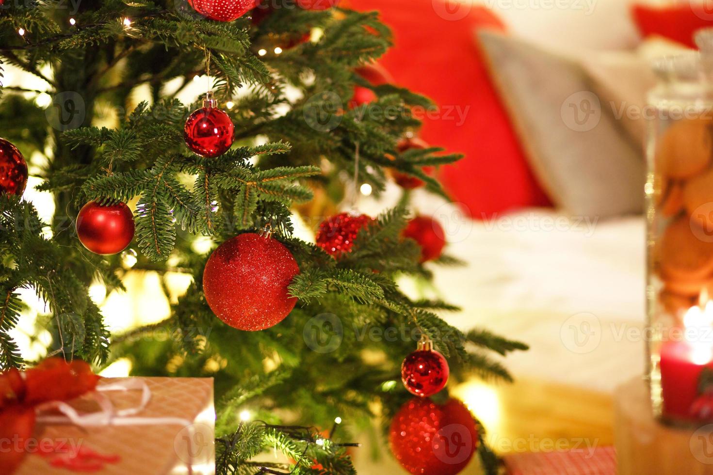decoración navideña roja en el árbol de navidad con guirnaldas de luces. año nuevo, elementos de decoración del hogar. espacio para texto foto
