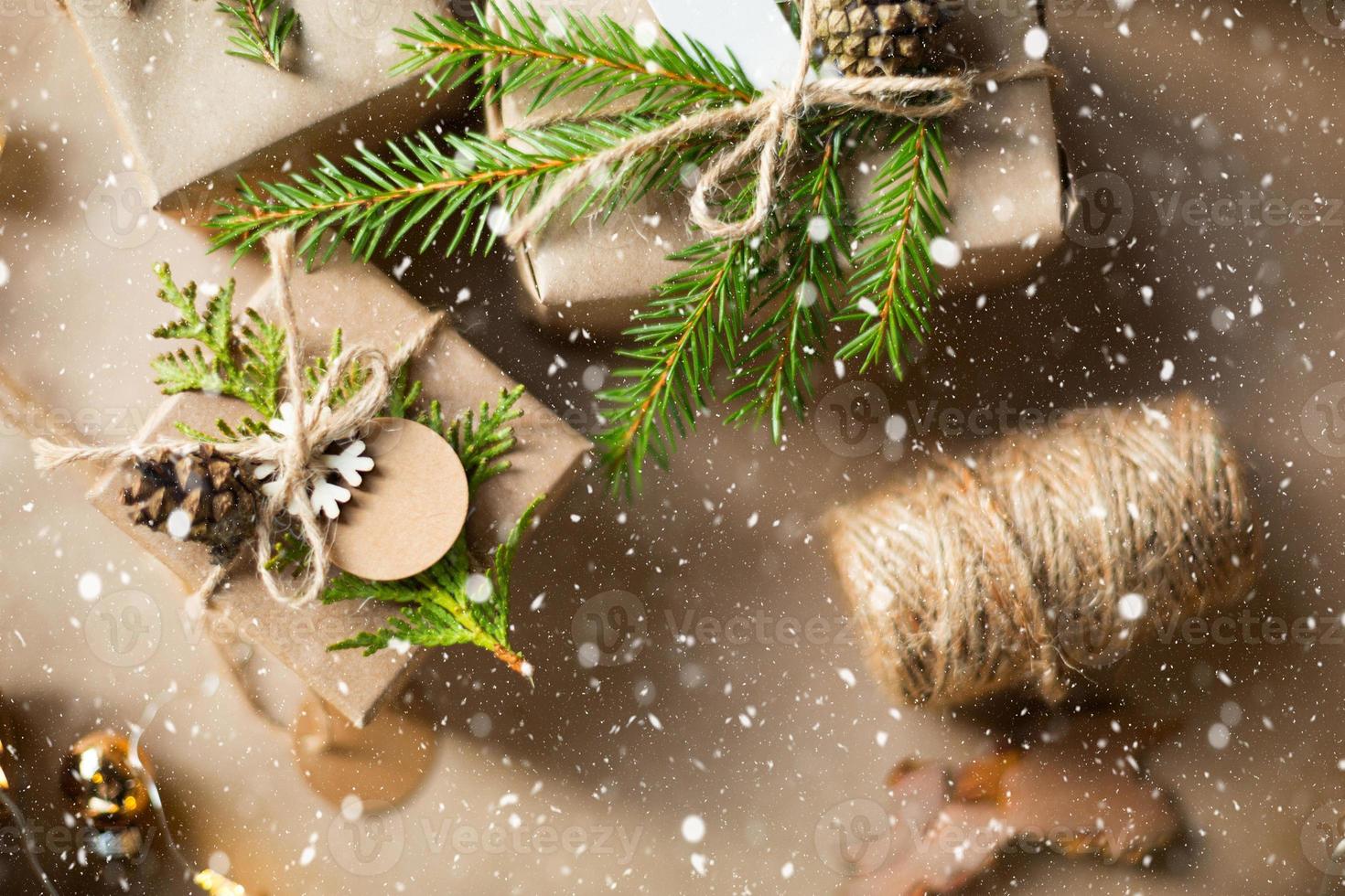 Pack a gift for Christmas and new year in eco-friendly materials kraft paper, live fir branches, cones, twine, snow. Tags with mock up, natural decor, hand made, DIY. Festive mood. Flatly, background photo