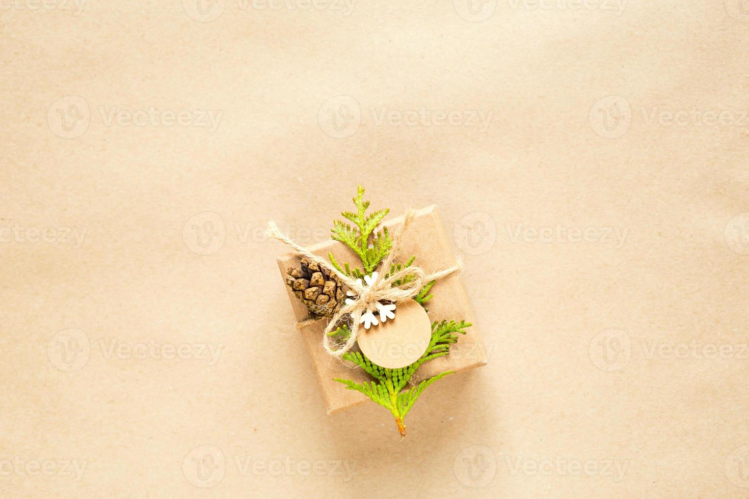 Gift box for Christmas and new year in eco-friendly materials kraft paper, live fir branches, cones, twine. Tags with mock up, natural decor, hand made, DIY. Flatly, background, frame, Minimalism photo