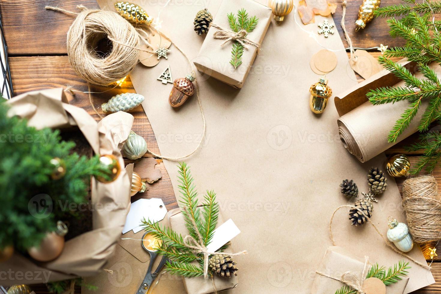 Background with copyspace for Christmas and new year in eco-friendly materials kraft paper, gift box, live fir branches, cones, twine. Tags with mock up, natural decor, hand made, DIY. Flatly photo