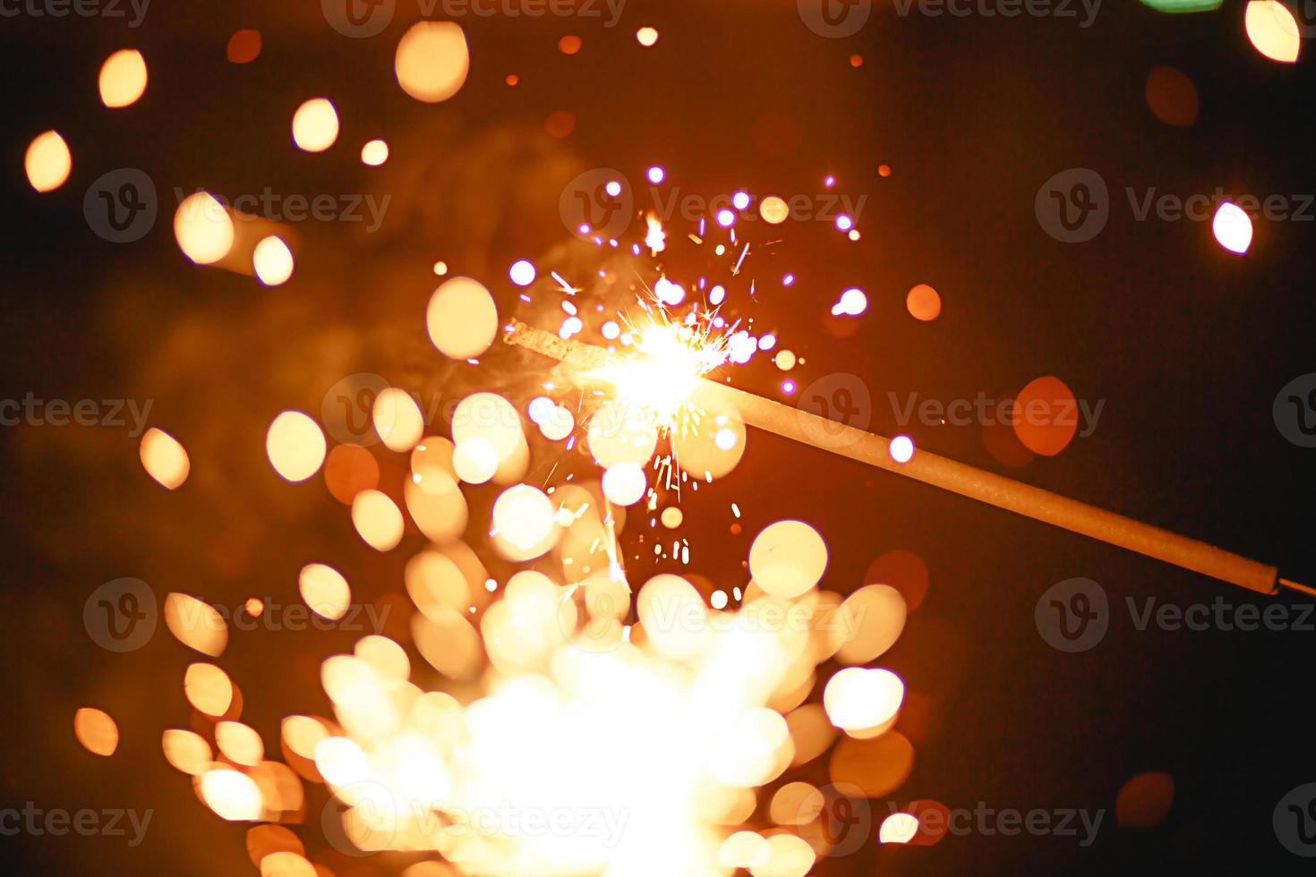 Sparks and sparklers in the dark. Festive fire texture, background for new year and Christmas. photo