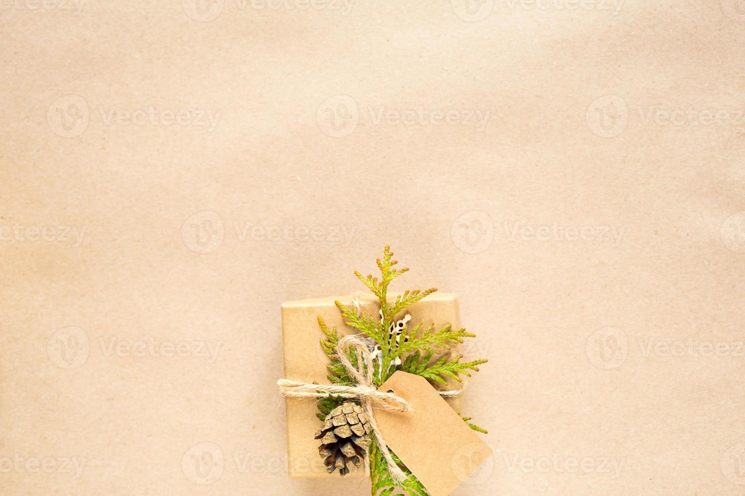 Gift box for Christmas and new year in eco-friendly materials kraft paper, live fir branches, cones, twine. Tags with mock up, natural decor, hand made, DIY. Flatly, background, frame, Minimalism photo