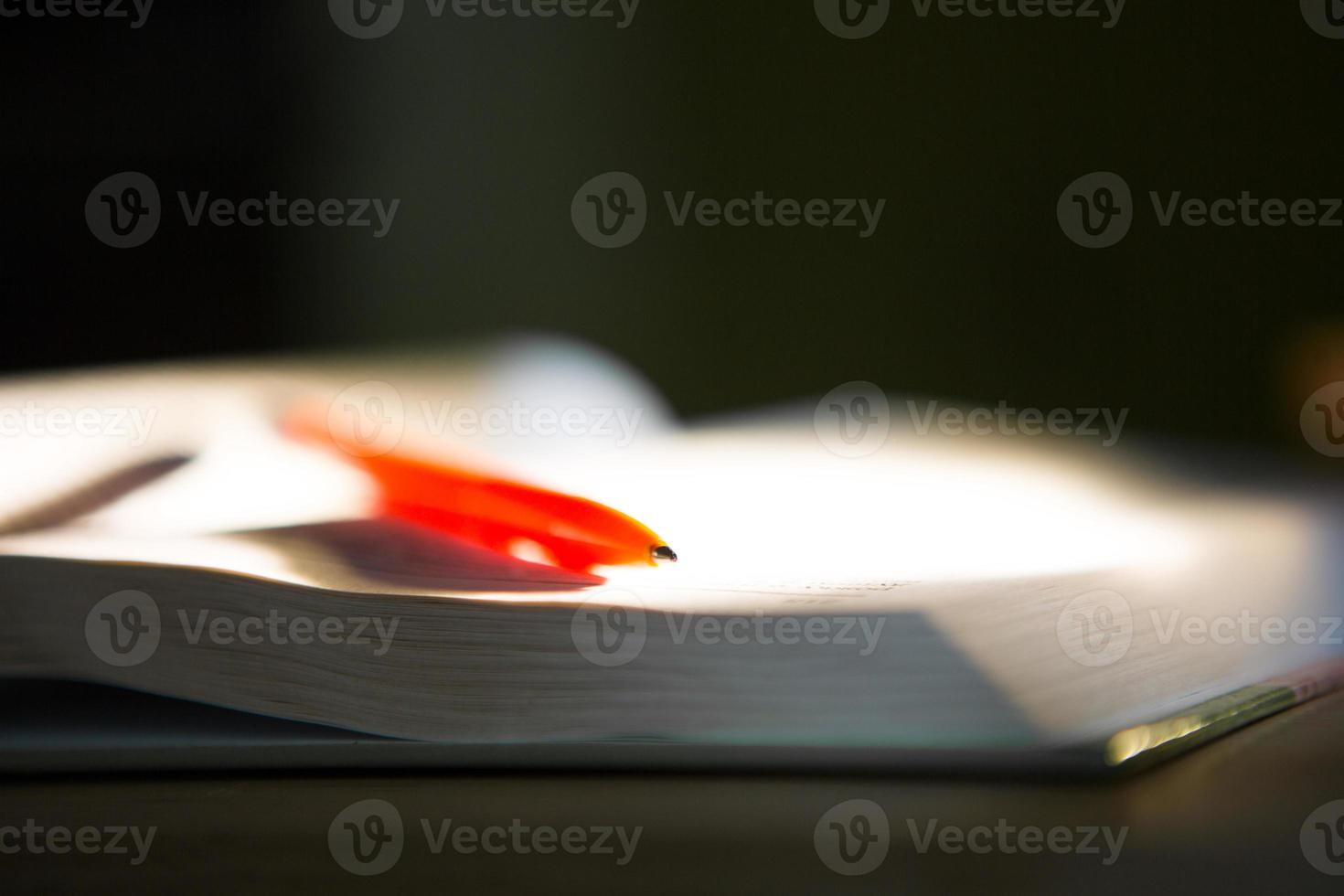 Close-up of a stack of books and a pen with paper for notes. The concept of home reading of paper books, education and school Institute, back to school, the library, making a synopsis. photo