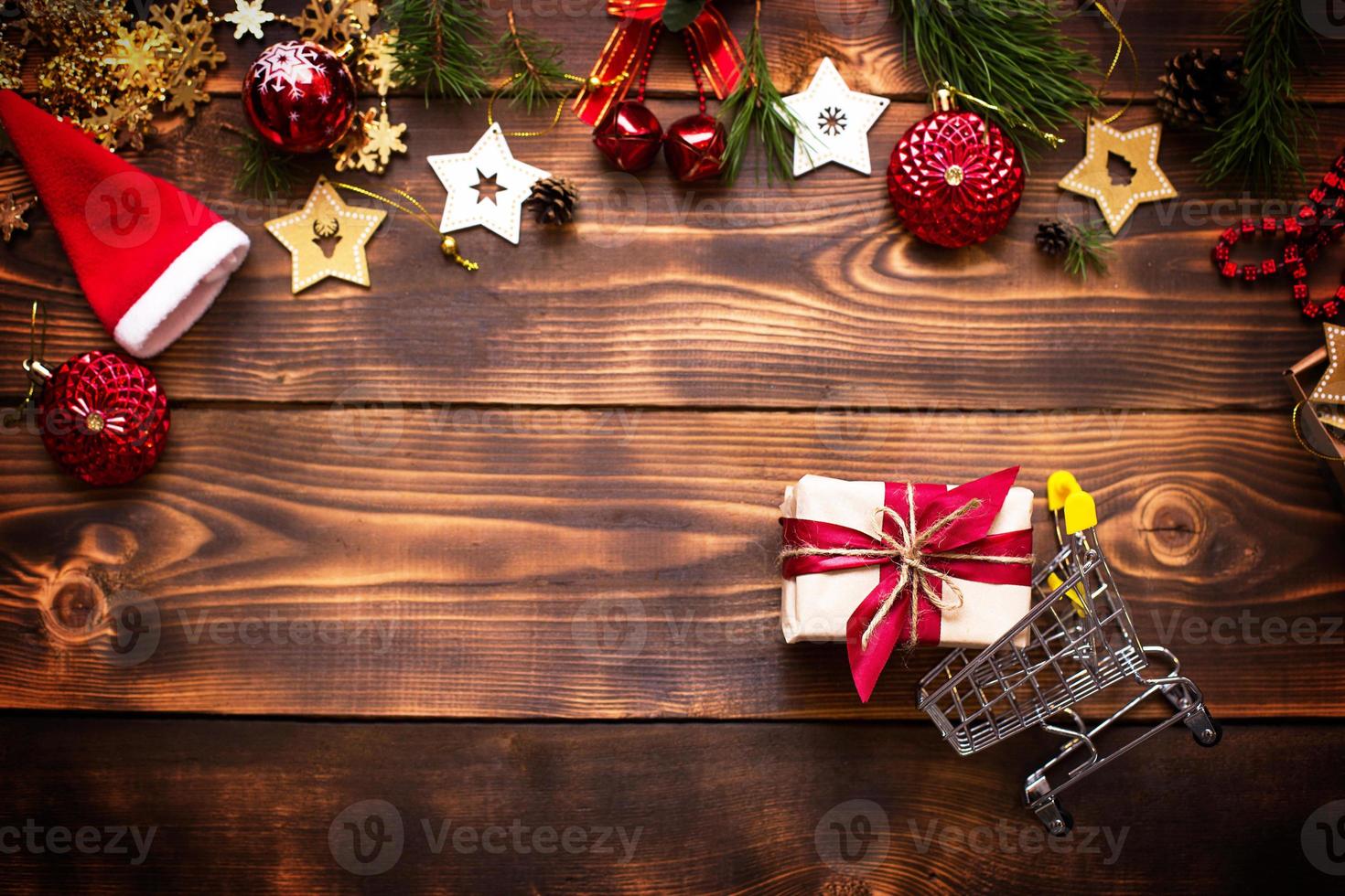 Christmas flat lay on the theme of shopping, buying gifts for the new year. Black Friday, sale, decor of stars, spruce branches, ball, beads, garlands, cones on a wooden background. Space for text photo