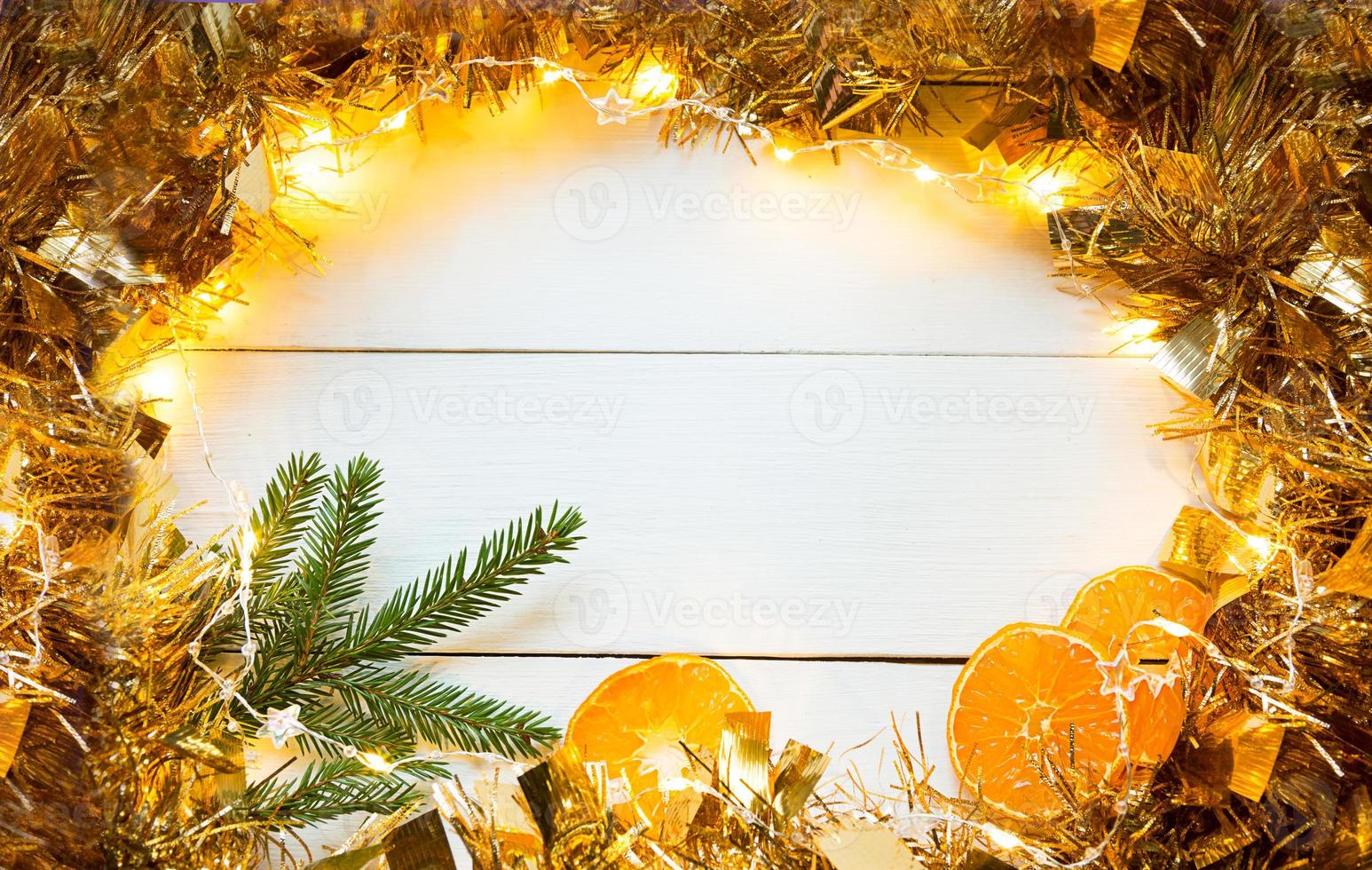 Slices of dried oranges, cinnamon sticks, fir branches. tinsel and gold garland on a white wooden background. Christmas, new year, holiday, warm autumn and winter atmosphere. Copy space, flat lay photo