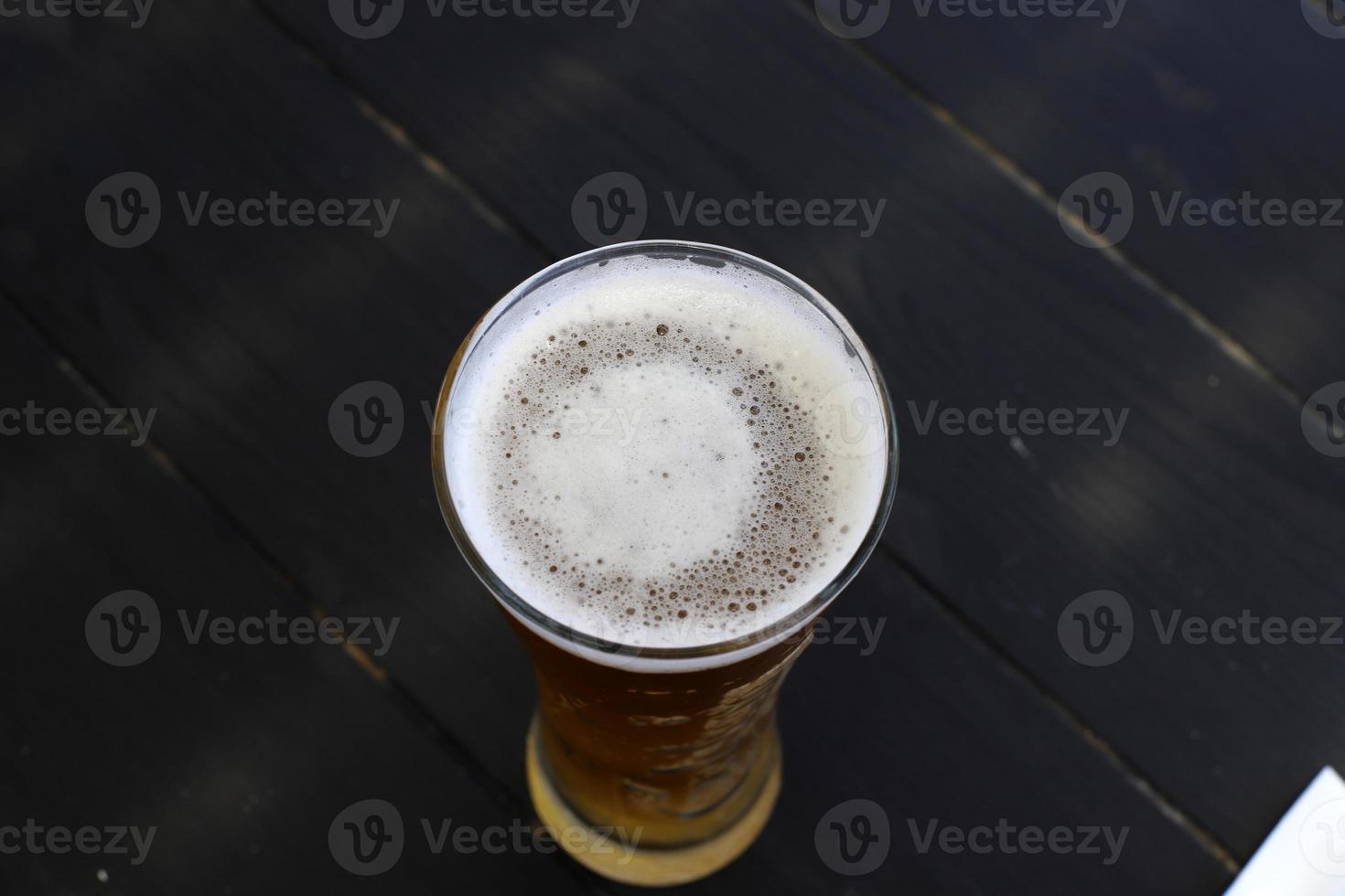 On the table in a mug fresh , light beer . photo