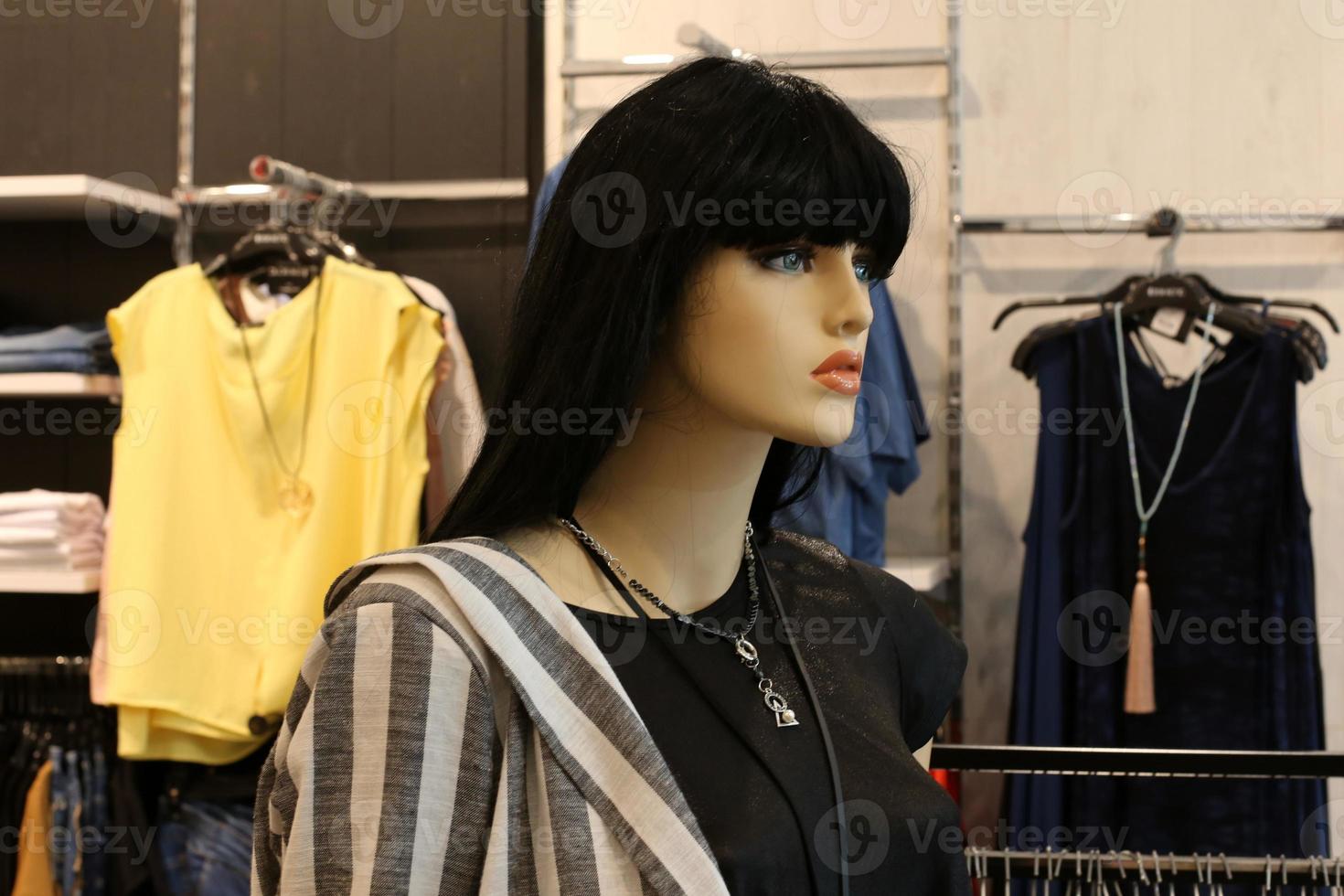 A mannequin stands on a showcase in a large store. photo