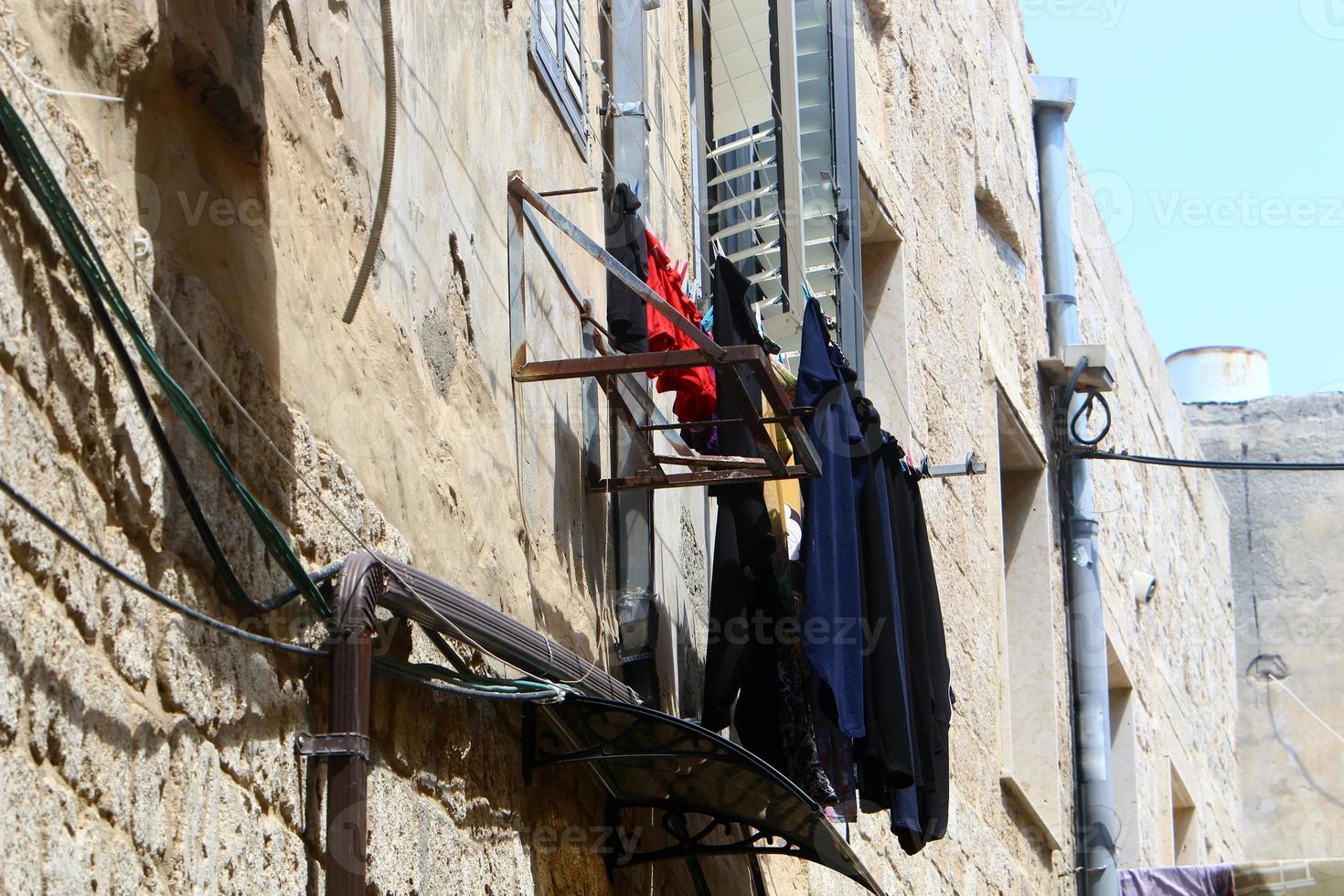 Washed linen dries on the street outside the window of the house. photo