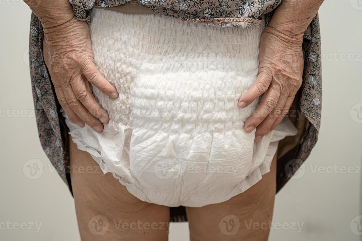 Paciente asiático mayor o mayor de la mujer de la señora mayor que lleva el pañal de la incontinencia en la sala del hospital de enfermería, concepto médico fuerte sano. foto