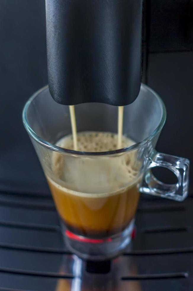 la máquina de café prepara una taza de americano foto