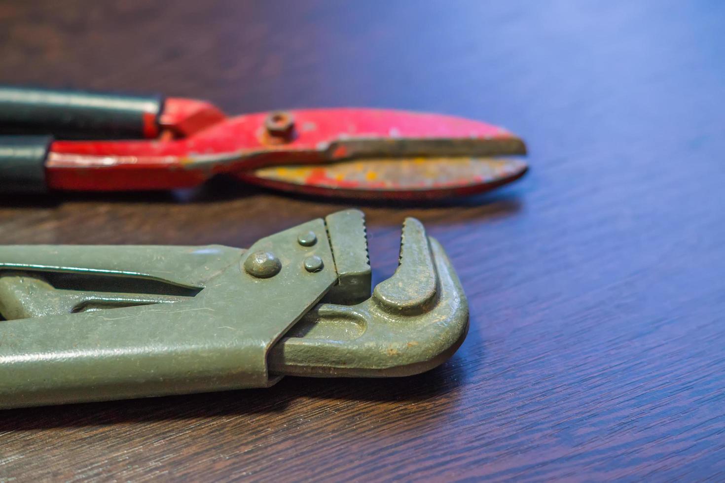 scissors for cutting metal and gas wrench on wooden table photo