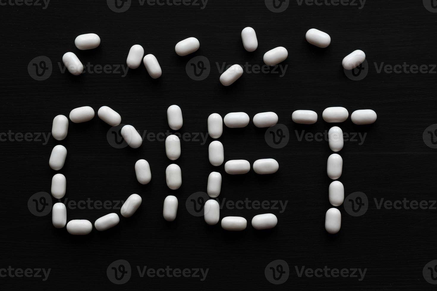 Medical concept written with pills word DIET On black wooden background with copy space photo