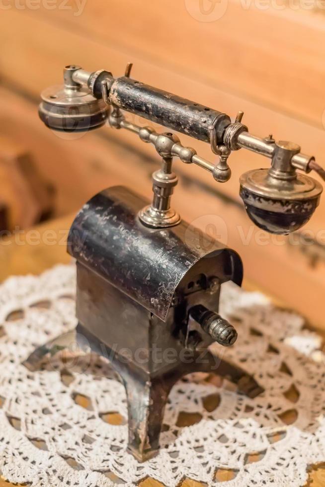 vintage retro phone on wooden table covered with openwork napkin photo