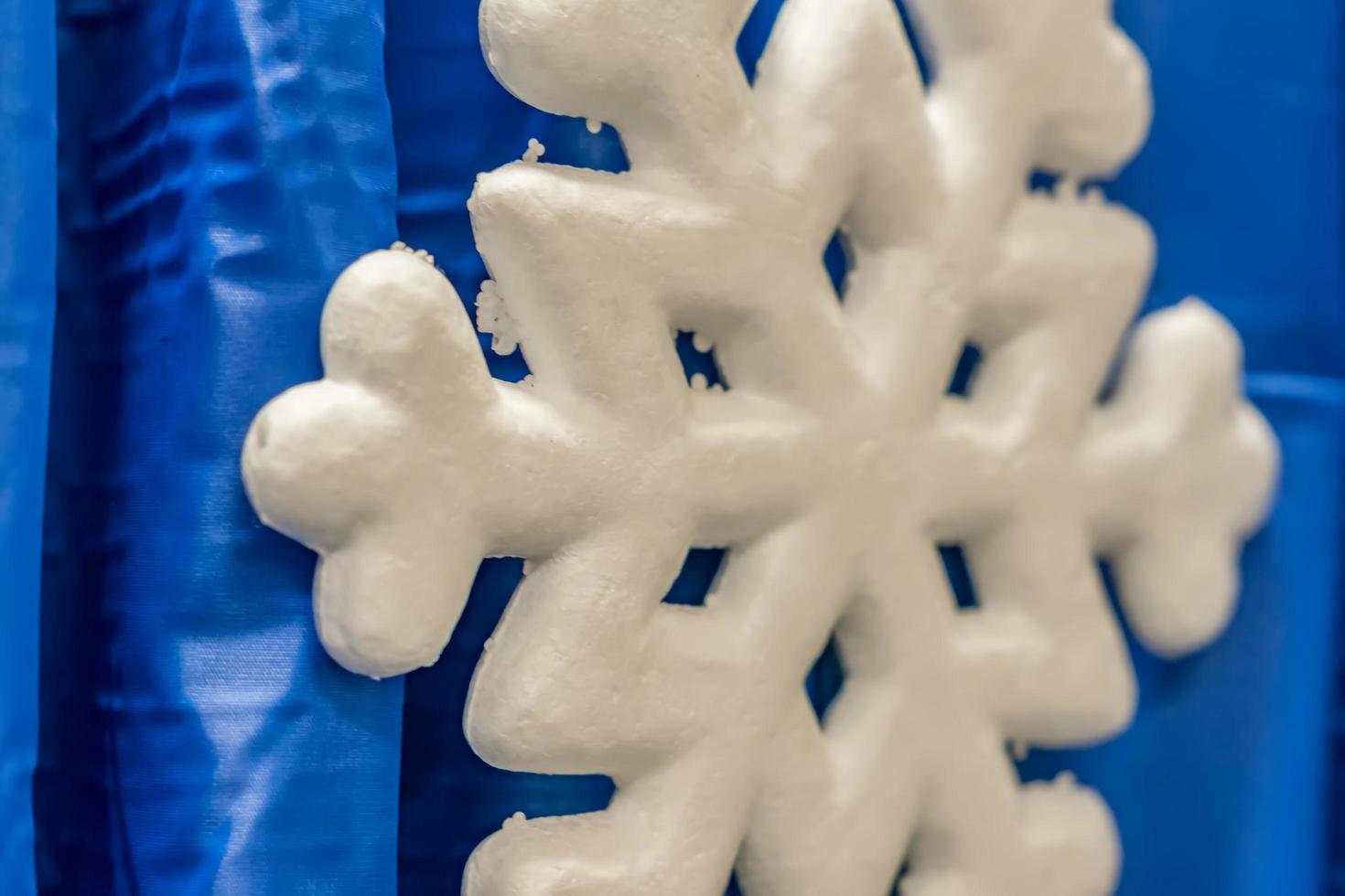 closeup of artificial snow flake on blue curtain background 9976873
