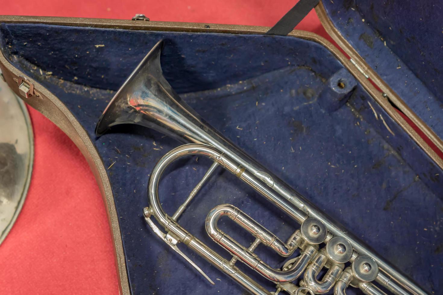 primer plano de una vieja trompeta en caso sucio foto