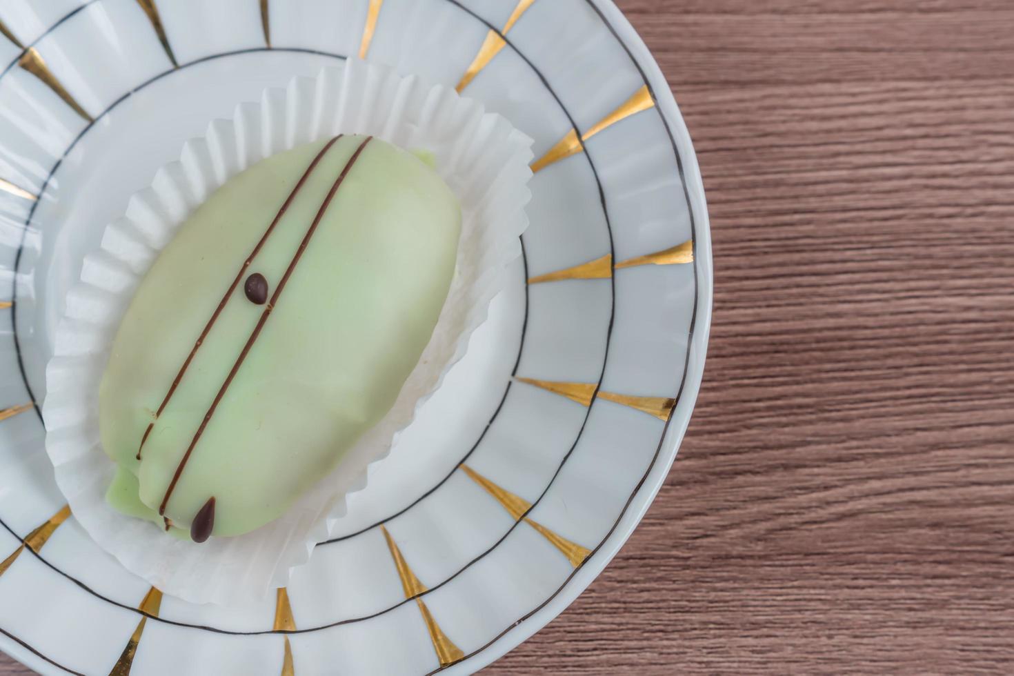 french eclair on a plate on wooden table photo