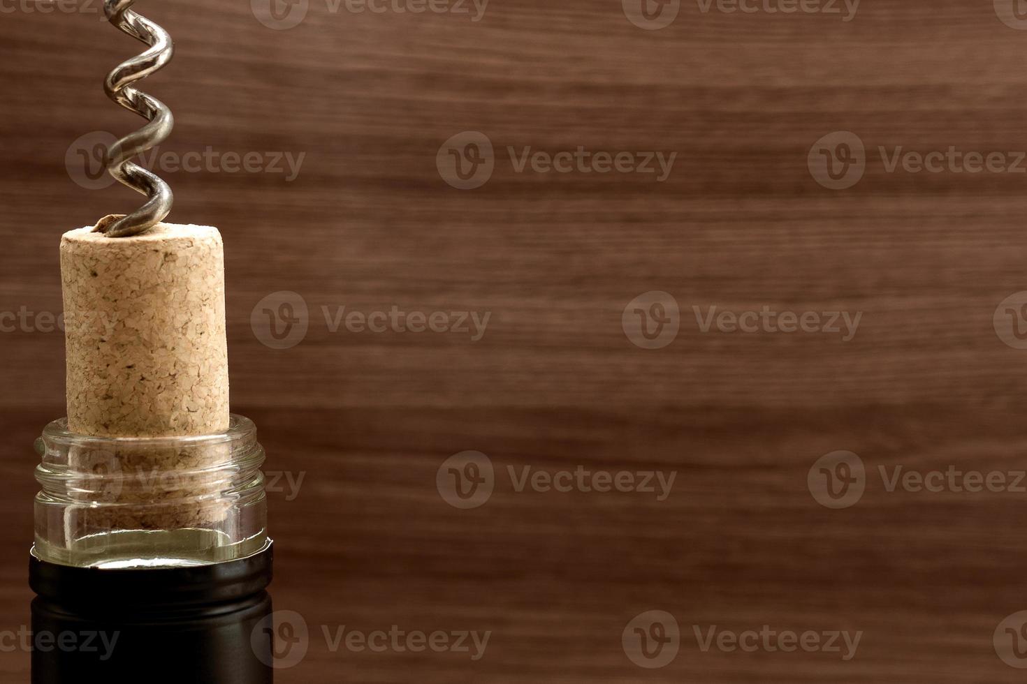 Bottle of wine with corkscrew on wooden background photo