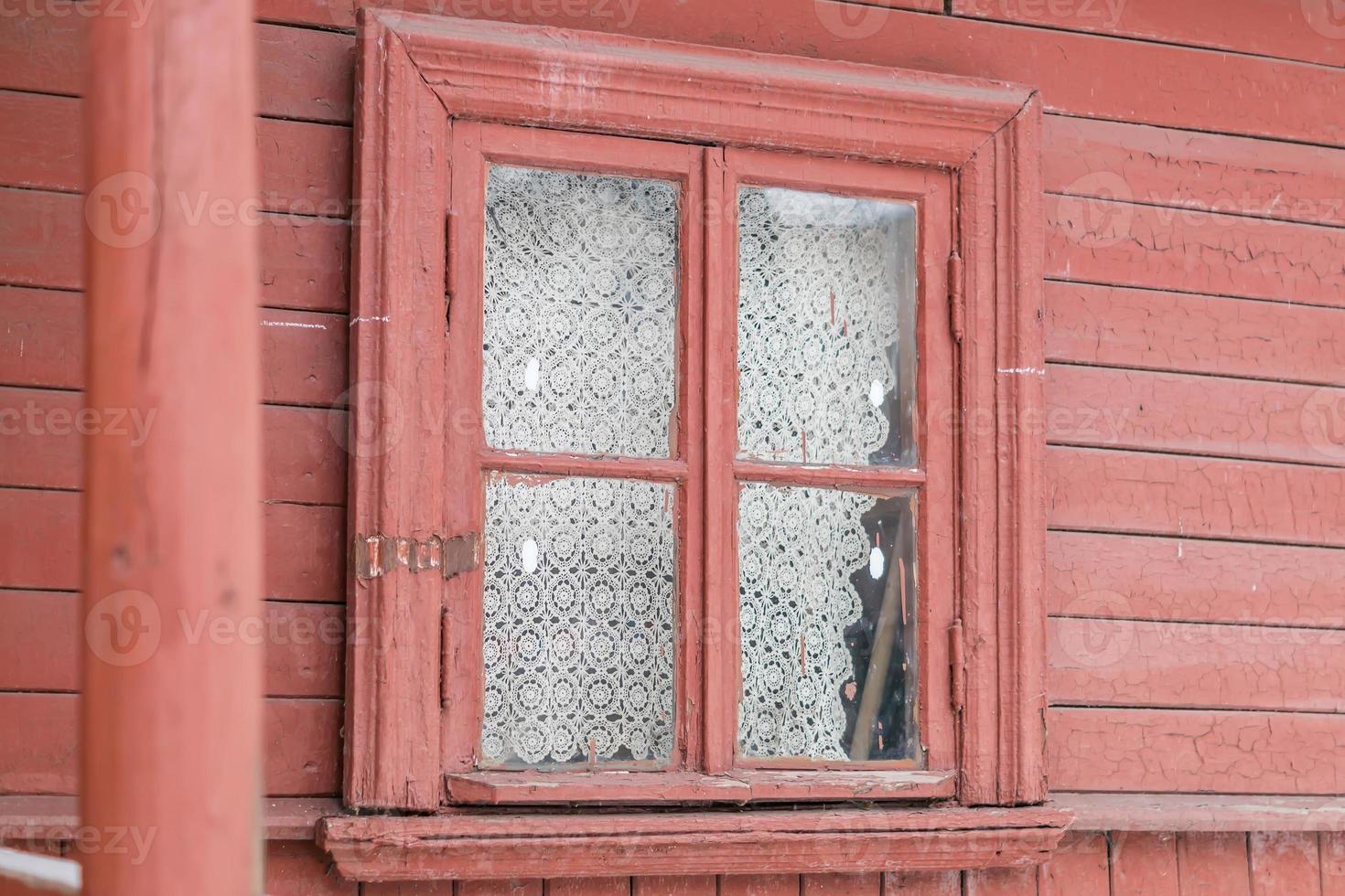 small window in wall of old wooden house photo