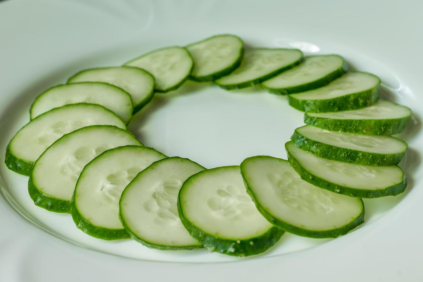 Multiple sliced cucumbers on a white plate photo