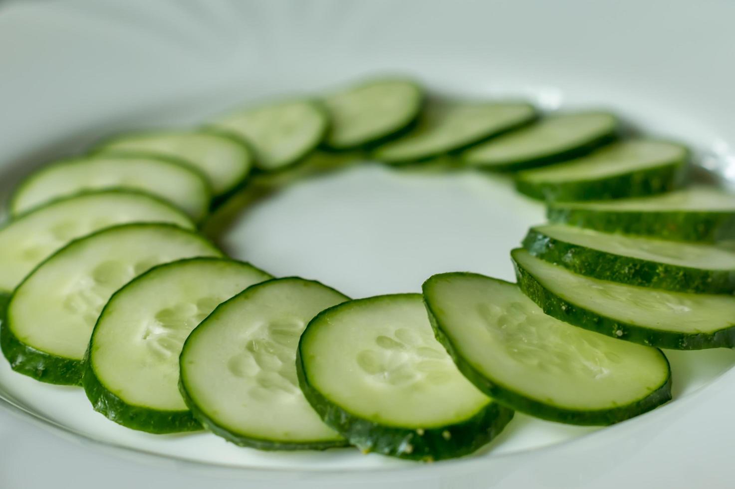 Multiple sliced cucumbers on a white plate photo