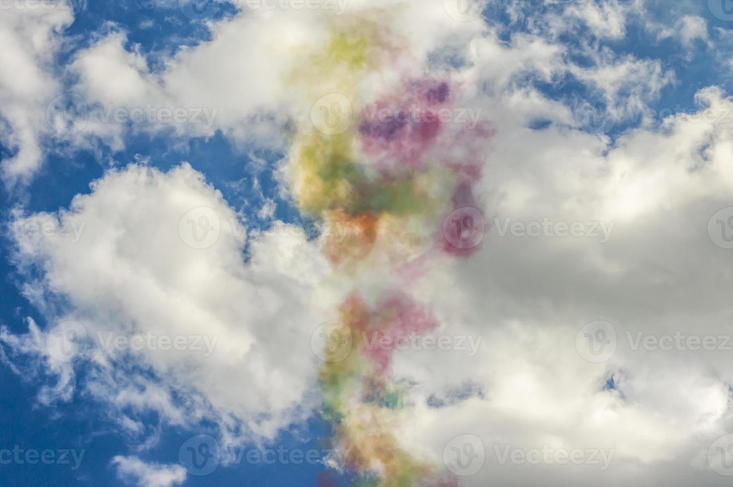 Colorful smoke in blue sky with clouds photo