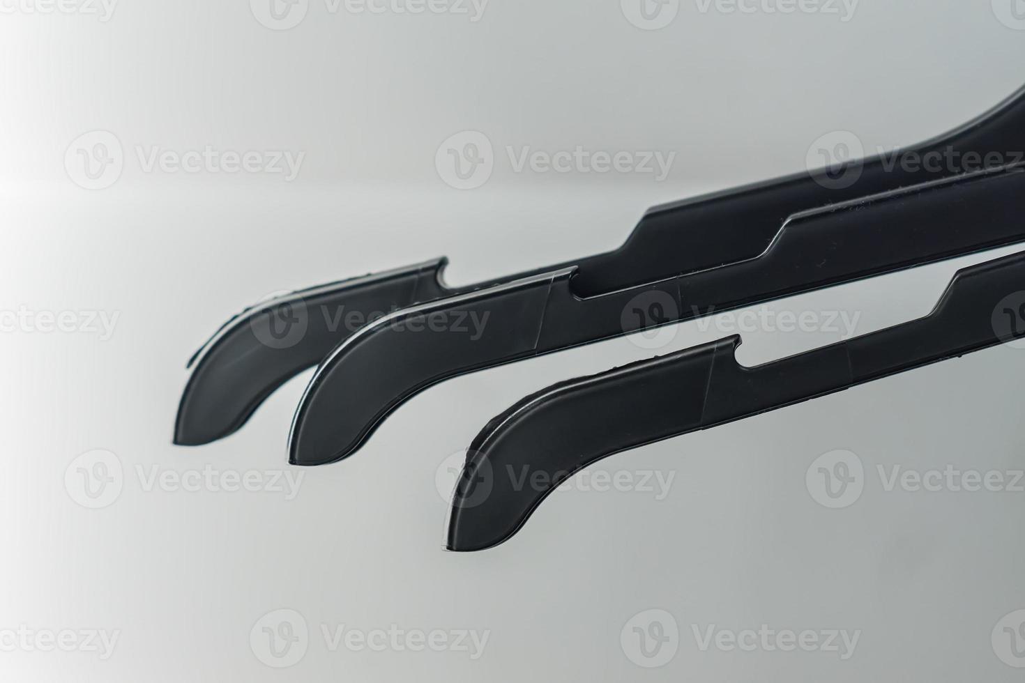 black plastic hangers on white wall background photo