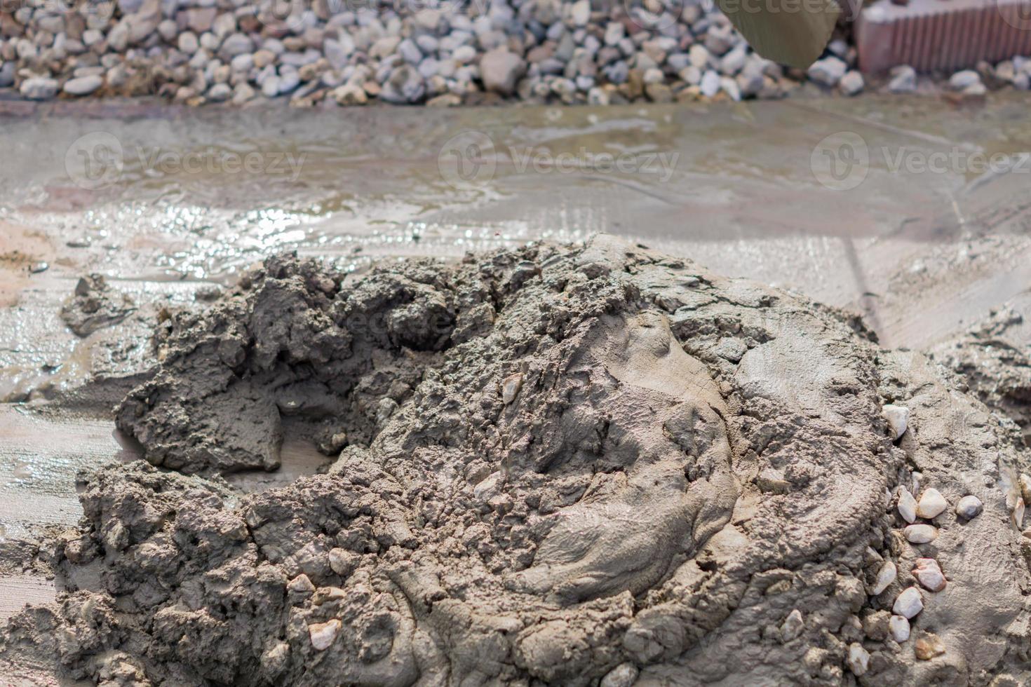 worker mixing concrete and gravel with spade on construction cite photo