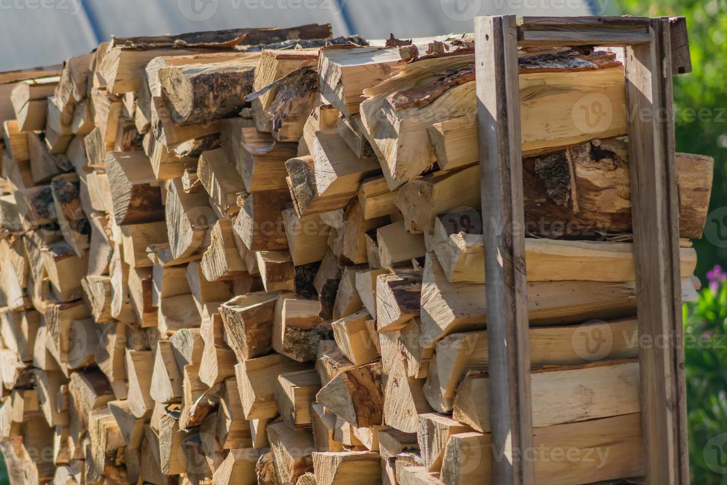 A stack of dry firewood, prepared for winter for heating the house. photo