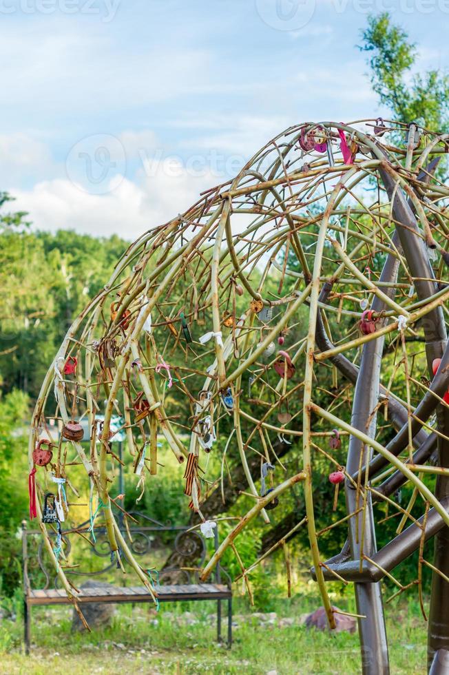 iron tree with plenty of locks near the road. Symbolic tree for locks - wedding tradition photo