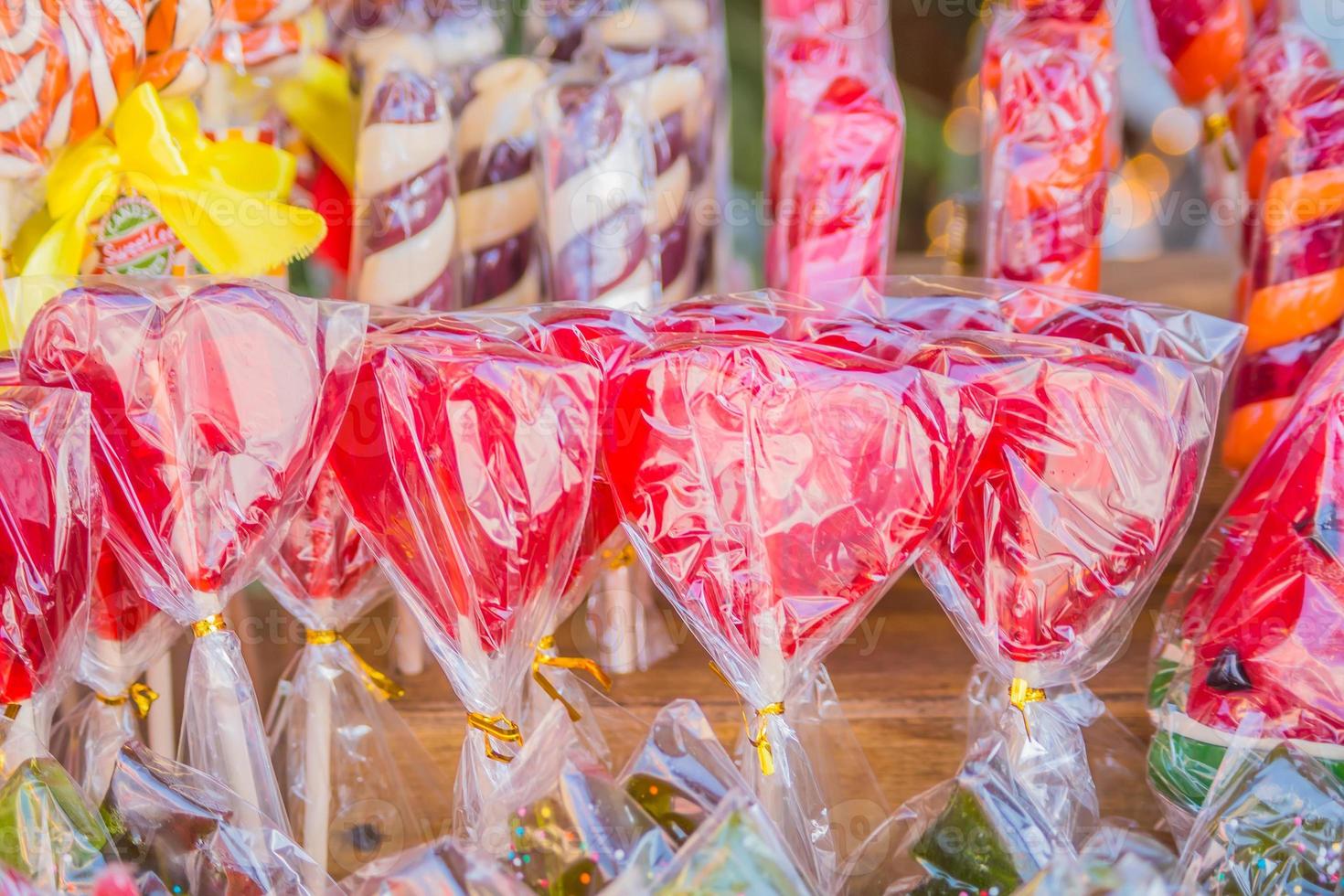 primer plano de piruletas de colores en forma de corazón en una tienda foto