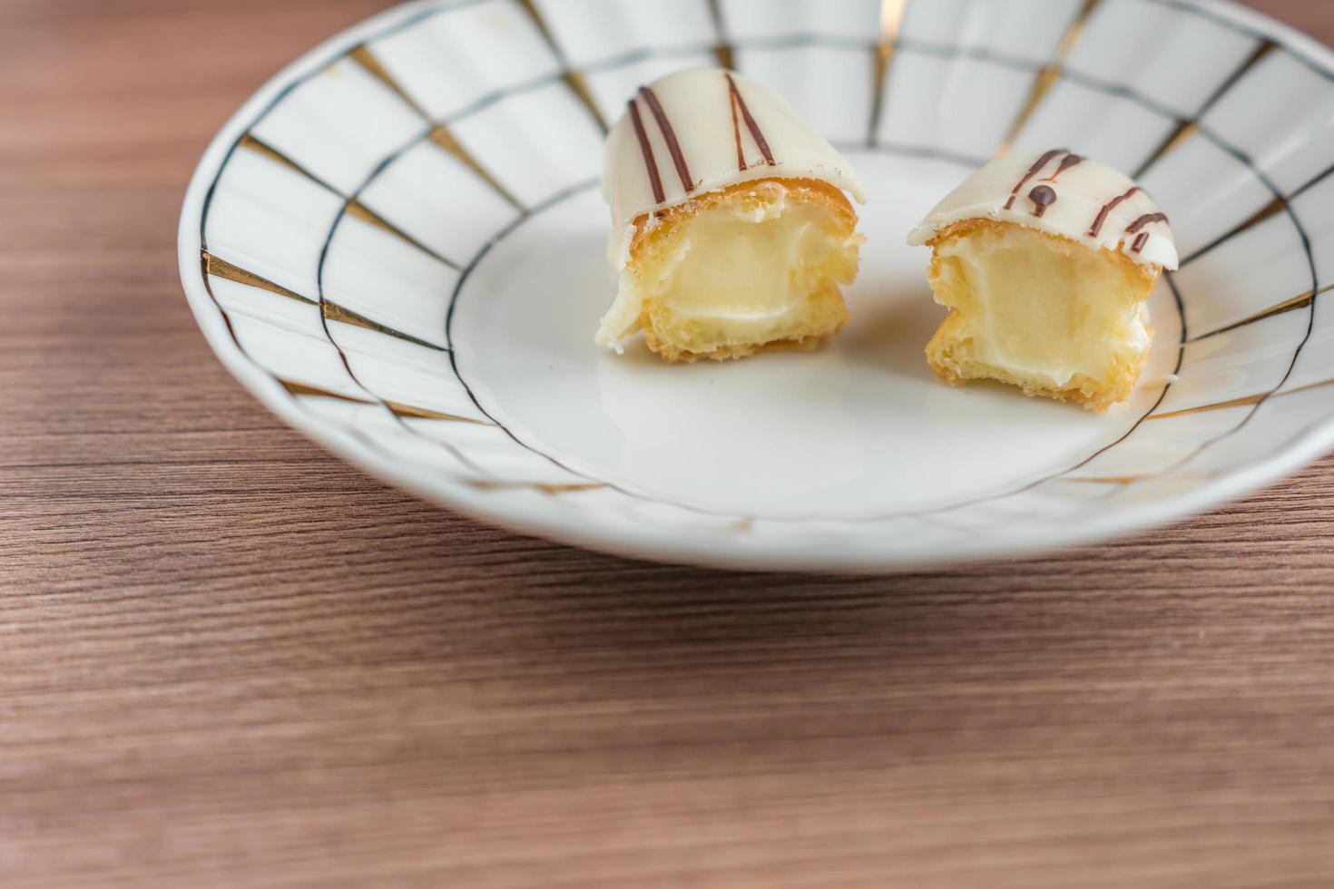 two halves of eclair on porcelain plate photo