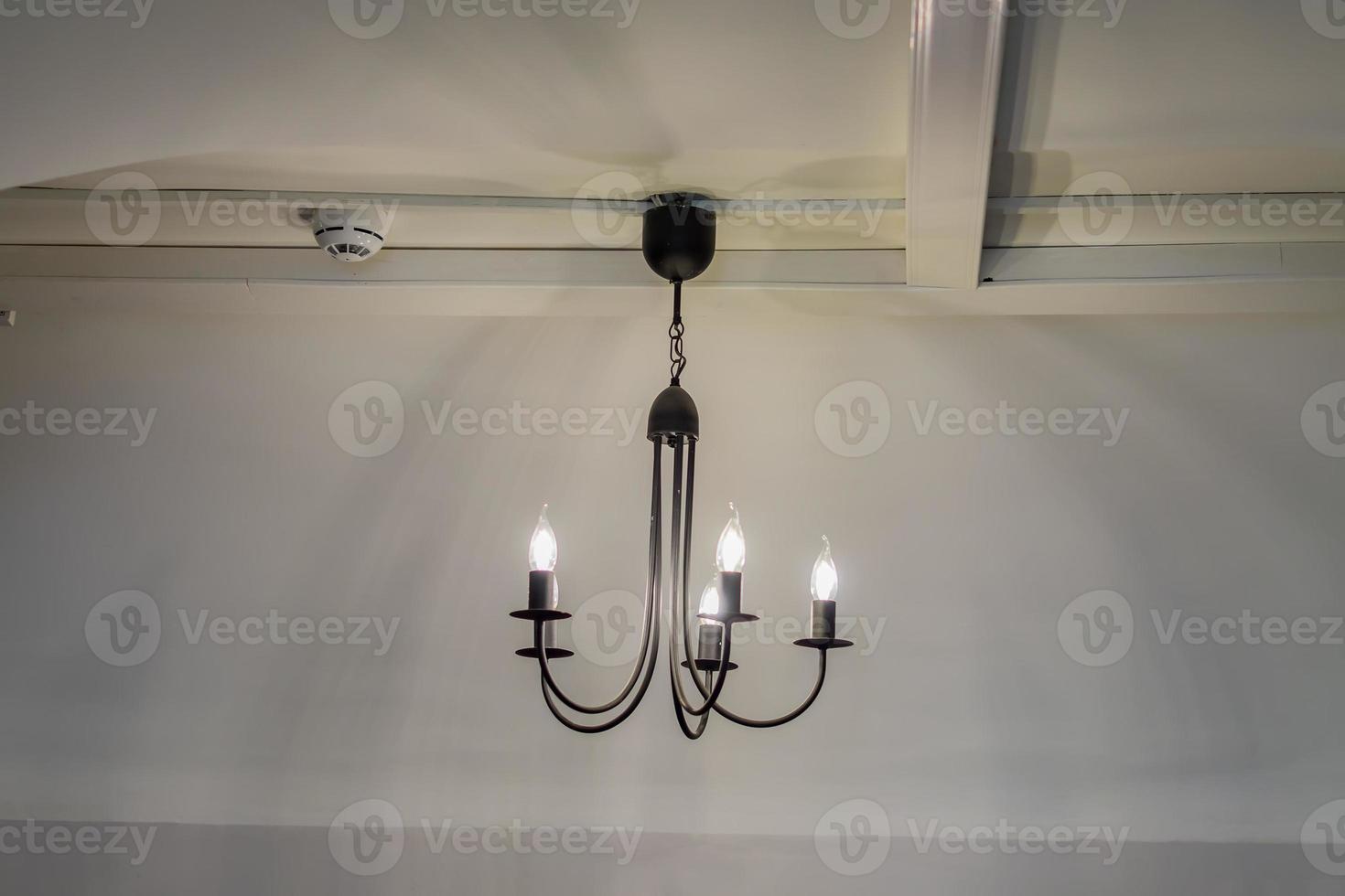 vintage chandelier hanging under white ceiling with stucco moldings photo