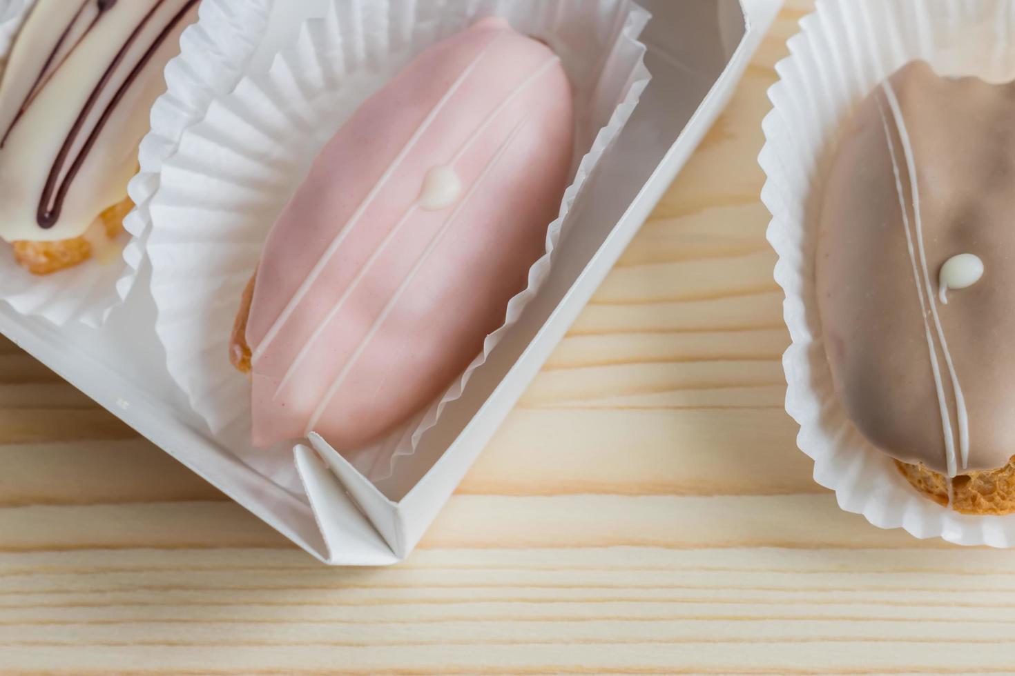 closeup of french eclairs in box on wooden background photo