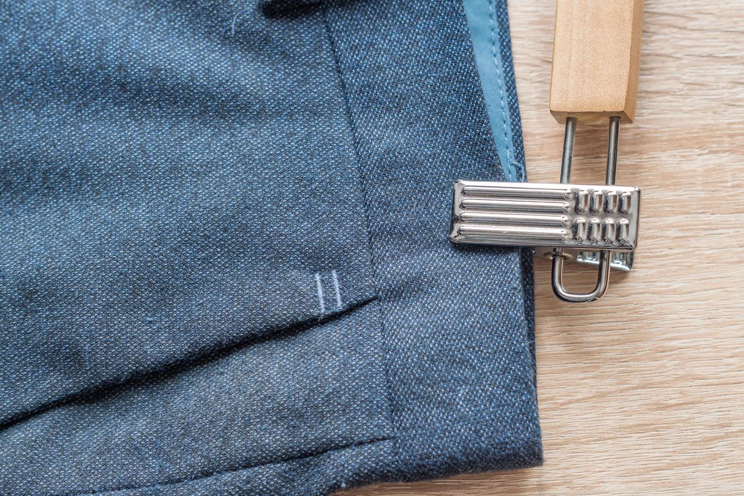 closeup of suit pants on wooden hanger photo