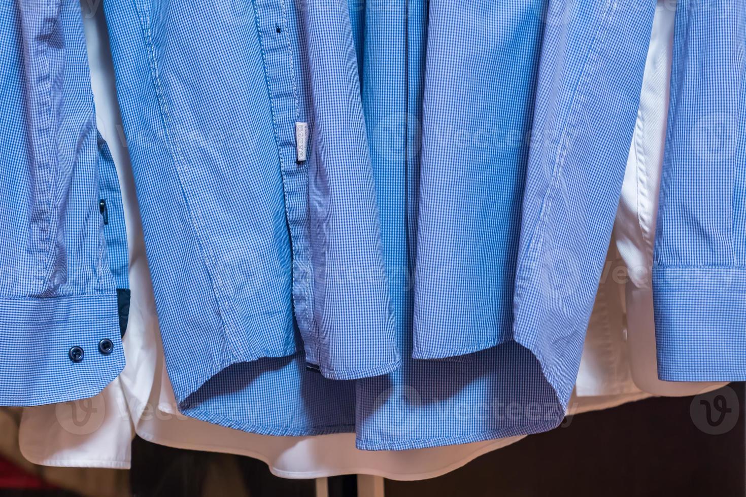 primer plano de dos camisas de hombre. camisas azules y blancas recién lavadas antes de planchar foto