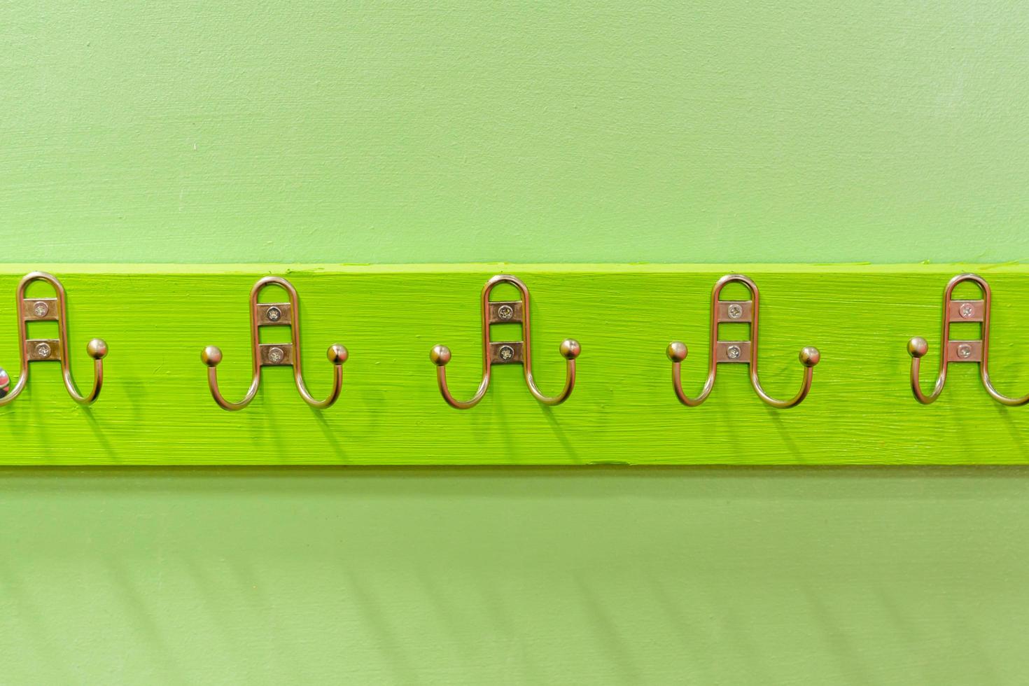 Metal Hanger Hook on green wooden desk photo