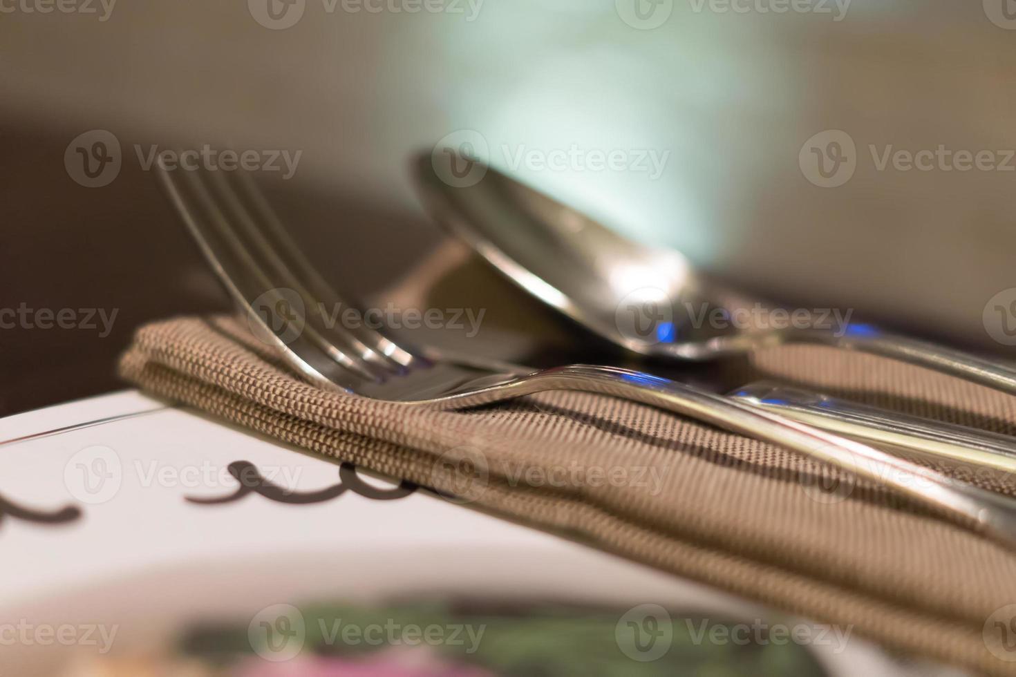 Served fork, spoon and knife on table. Soft focus photo