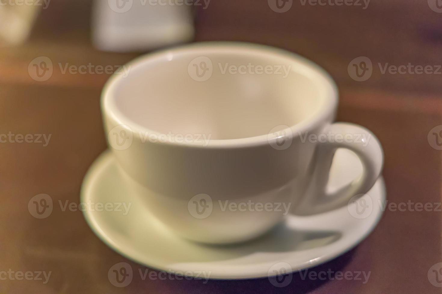 white tea cup and saucer on table. Soft focus photo