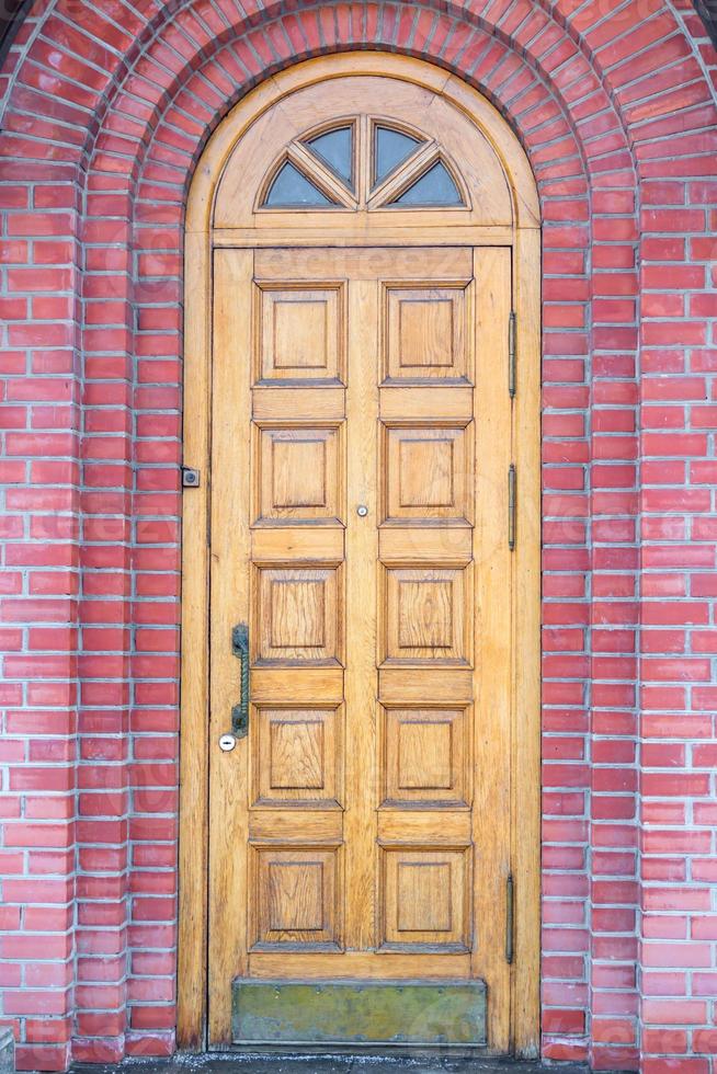 wooden door and red brick wall closeup photo