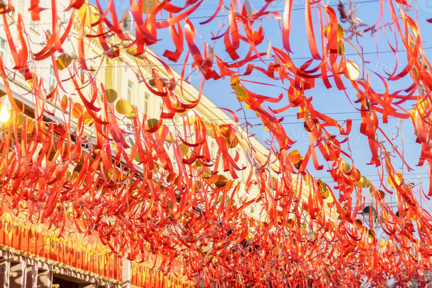 red strips of cloth hanging on a string against blue sky photo