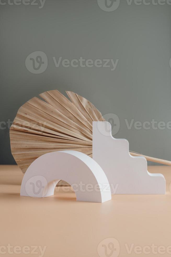 White concrete podium and palm leaf on grayand beige copy spase background. Minimal empty display product presentation scene. photo