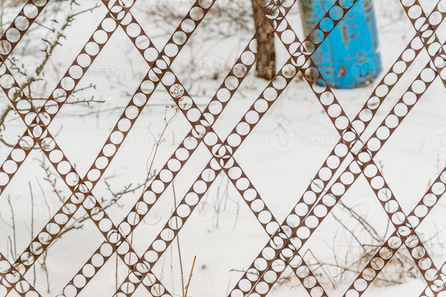 perforated fence on snow background. photo