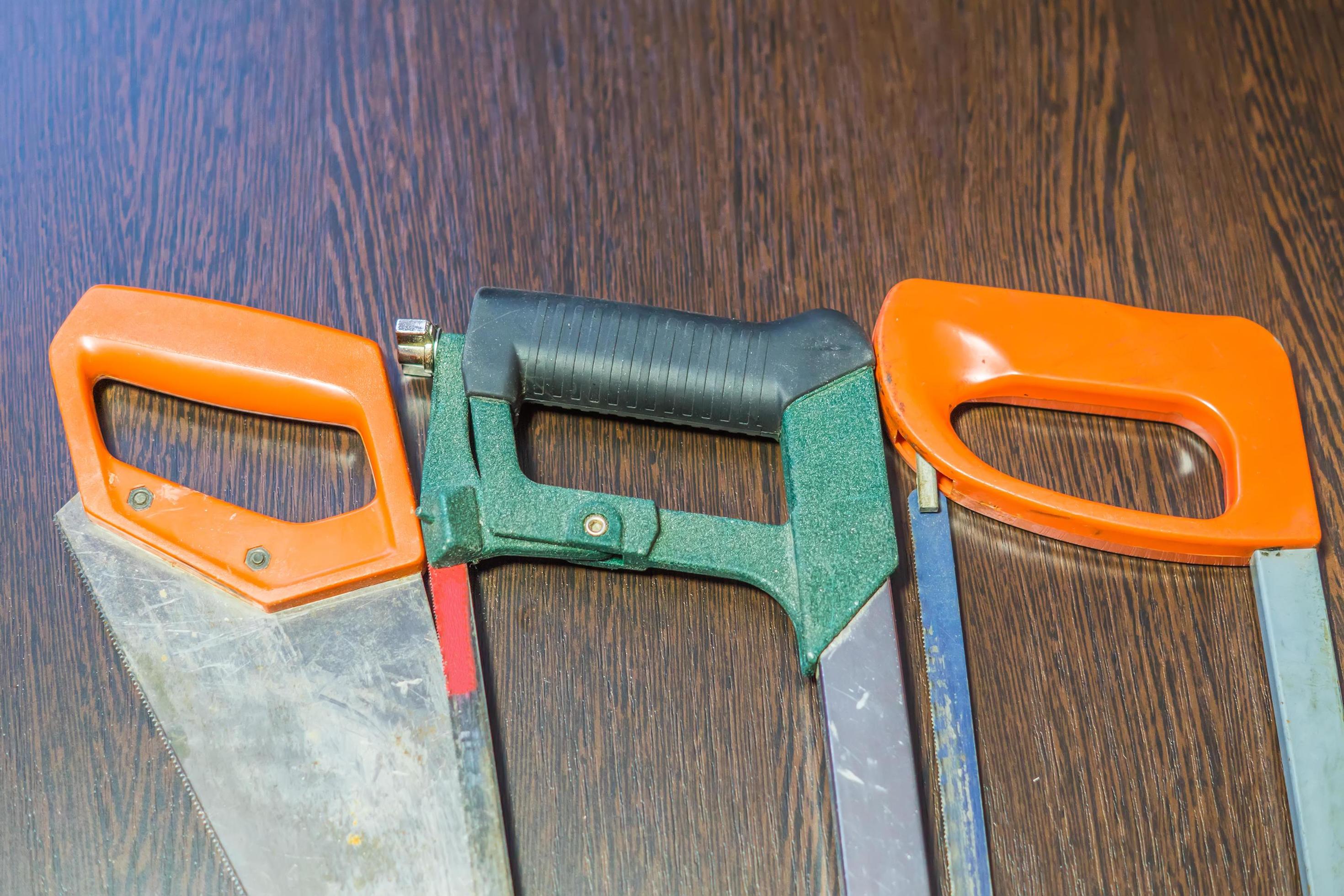 three various handsaws on wooden background 9982052 Stock Photo at Vecteezy
