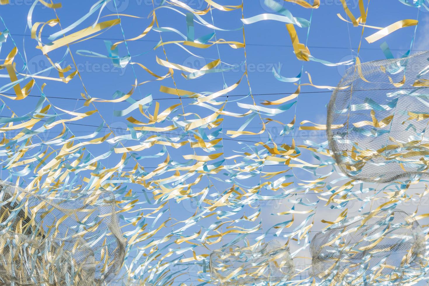 white, blue and gold strings against blue sky, street festival decoration photo