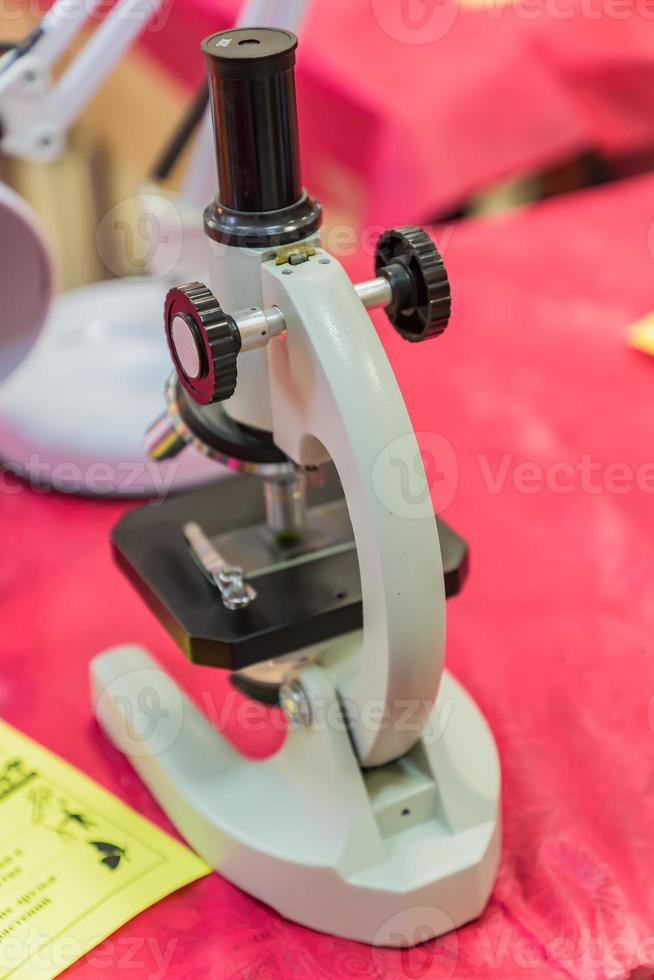 Laboratory Equipment, Optical Microscope for school lessons on red table photo