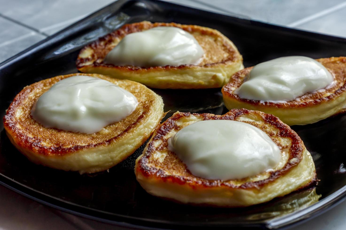 pancakes with natural yogurt on black plate photo