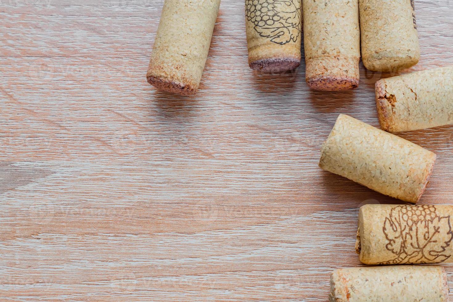 top view of used vine corks on wooden background with copy space photo