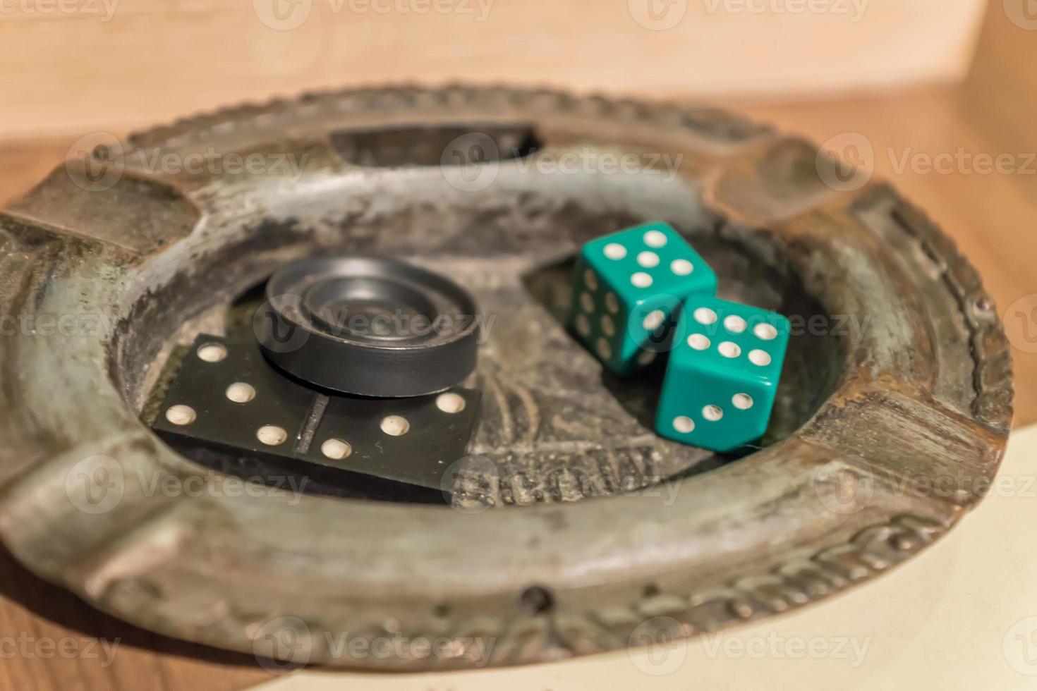 checker and playing dice in ashtray on the wooden table photo