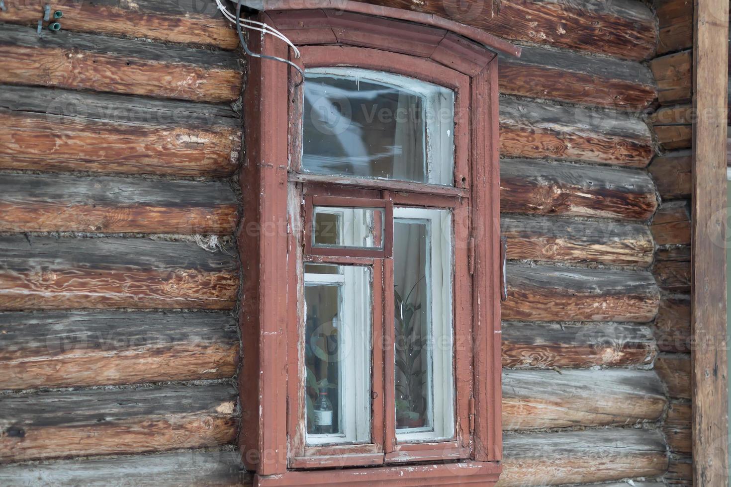 small window in wall of old wooden house photo